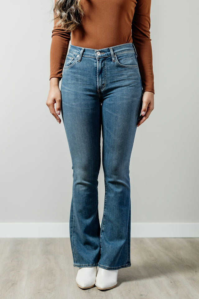 Pictured is a low-rise denim jean with a medium-wash, bootcut leg, and stretchy fit.