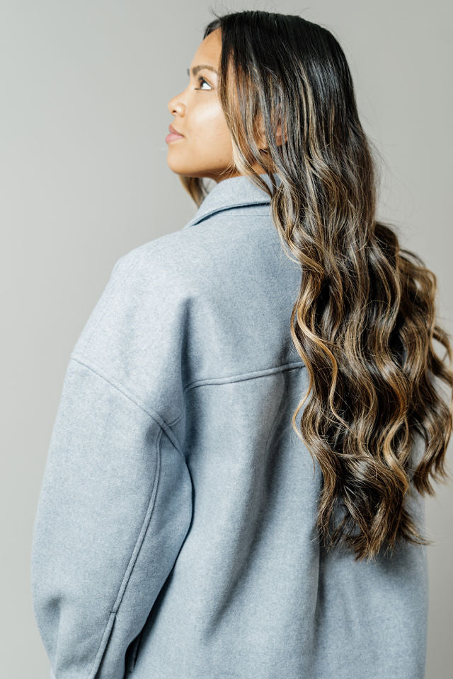 Pictured is a sturdy jacket with snap button closures, cuff sleeves, front pockets, and a gray-blue hue.