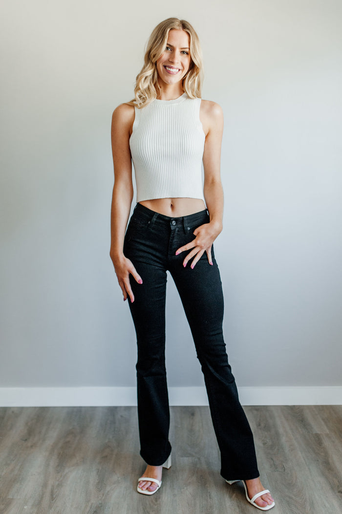 Pictured is a black pair of denim with a mid-rise fit with a slim body and flare at the bottom.