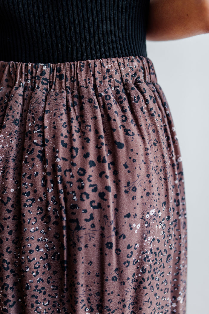 Pictured is a velvet-purple, print midi skirt with an animal print pattern, high-waisted fit, and side slit.
