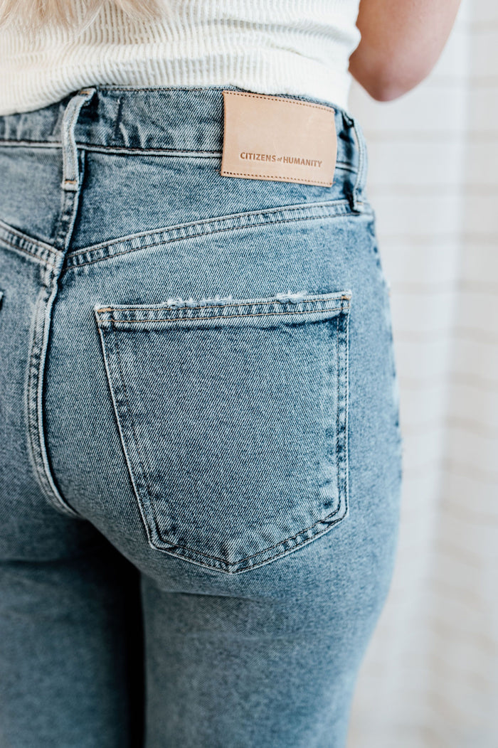 Light wash, mid-rise denim with knee distressing on model.