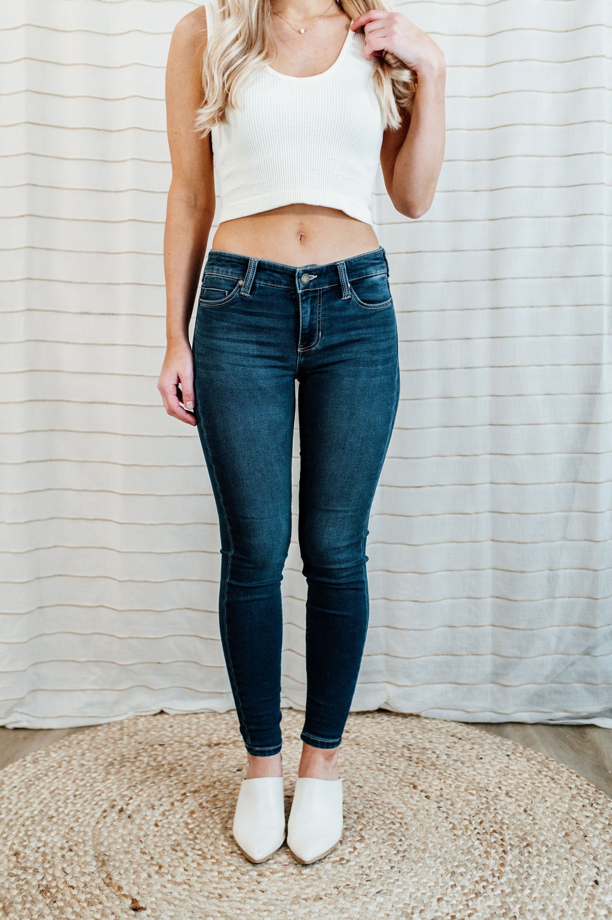 Pictured are med-wash, denim skinny jean with a low-rise waist, dark-wash, and skinny fit.