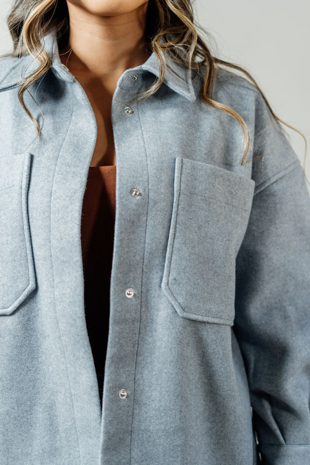 Pictured is a sturdy jacket with snap button closures, cuff sleeves, front pockets, and a gray-blue hue.