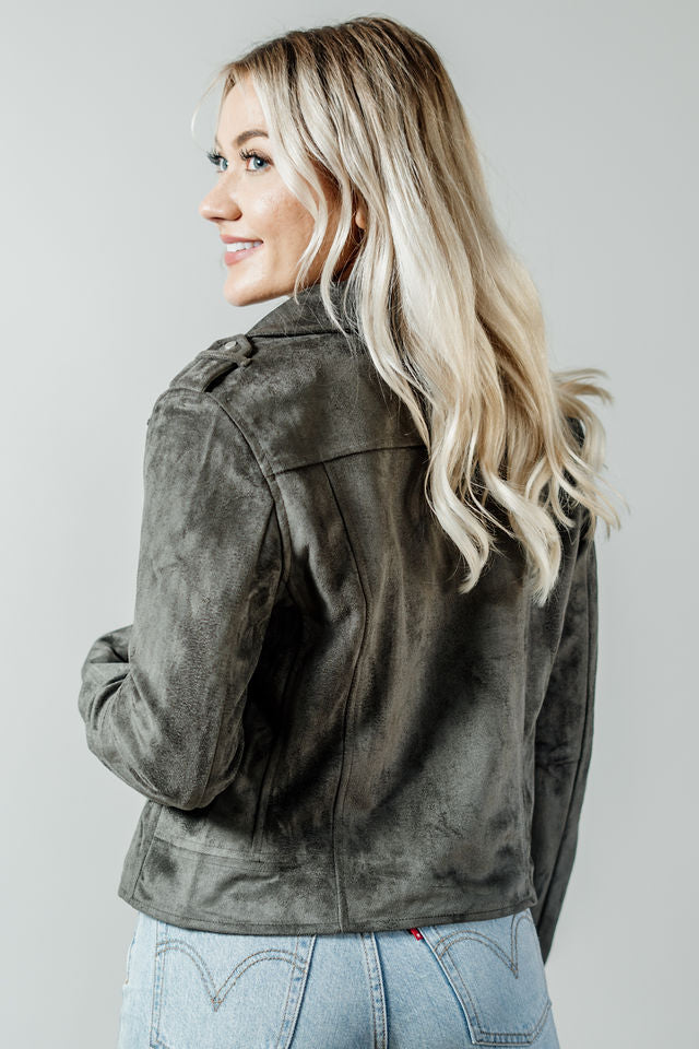 Pictured is a grunge-green, suede jacket with a moto-style collar, zipper closure, and side pockets with zippers.