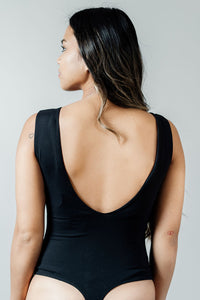 Pictured is a black bodysuit with a v-neckline,  double-lined material, thick shoulder straps, and two-button closure.