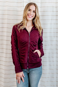 Velvet purple-red, zip up jacket with side and sleeve ruching on model.