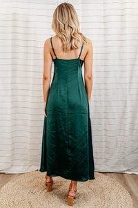 Pictured is a green, silky midi dress with a v-neckline, adjustable shoulder straps, seamless side-zipper, and deep side slit.