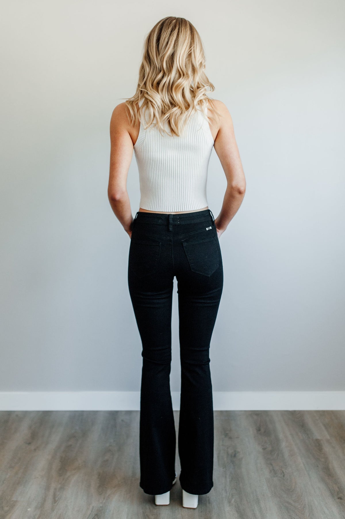 Pictured is a black pair of denim with a mid-rise fit with a slim body and flare at the bottom.