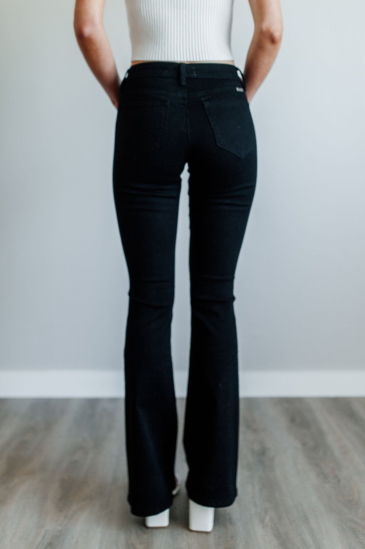 Pictured is a black pair of denim with a mid-rise fit with a slim body and flare at the bottom.