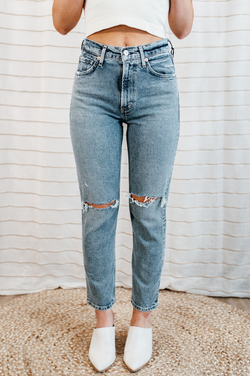 Light wash, mid-rise denim with knee distressing on model.