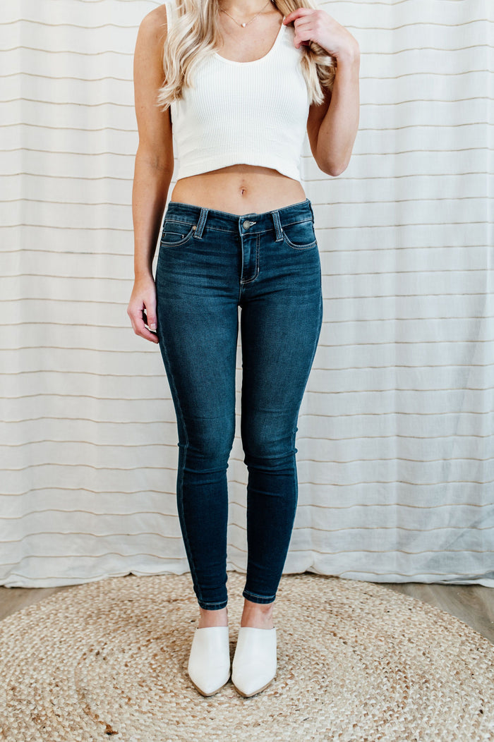 Pictured are med-wash, denim skinny jean with a low-rise waist, dark-wash, and skinny fit.